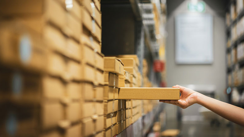 Woman takes box from warehouse shelf