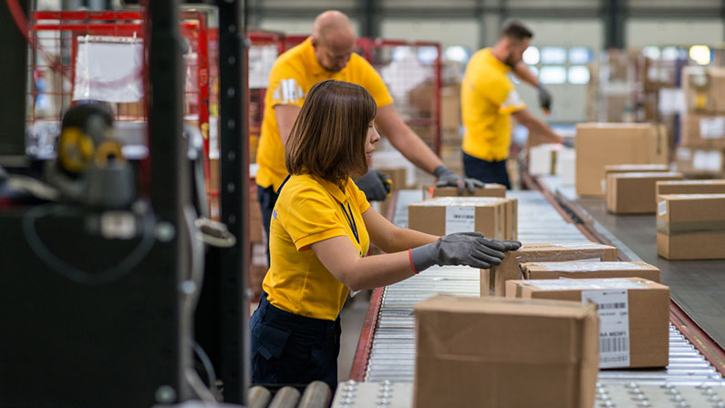 Young woman checks boxes on a conveyor belt